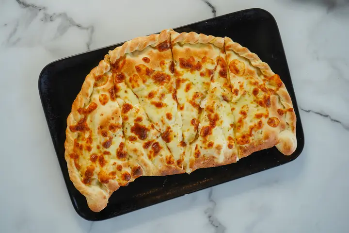 A folded pizza on a board