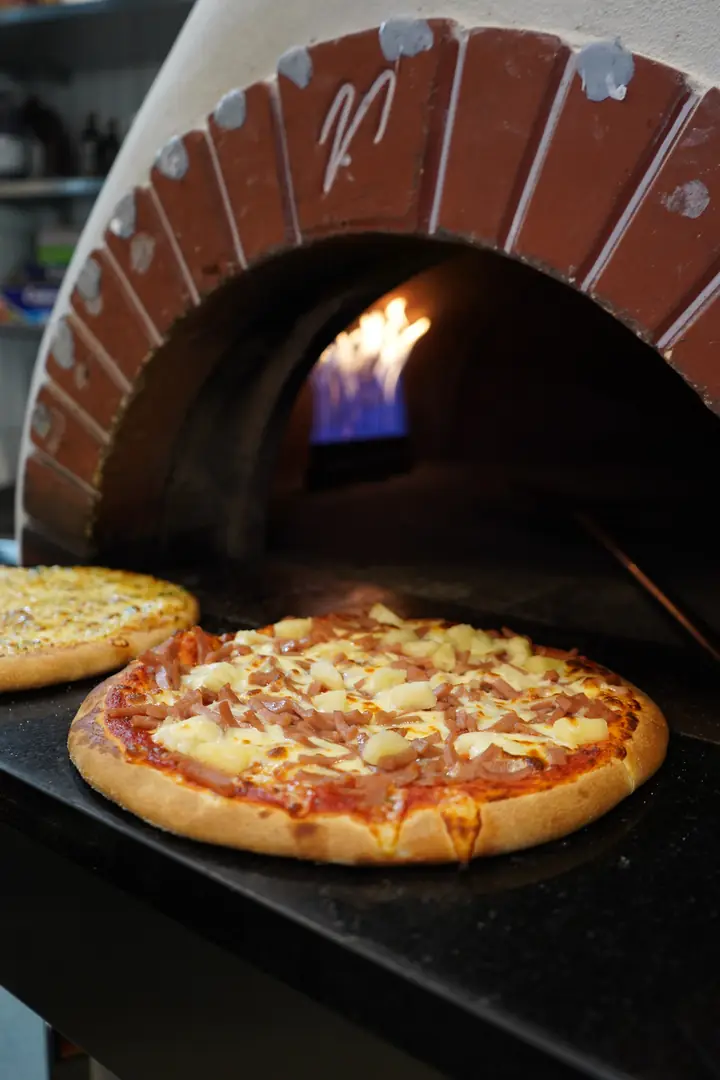 A pizza in front of the oven